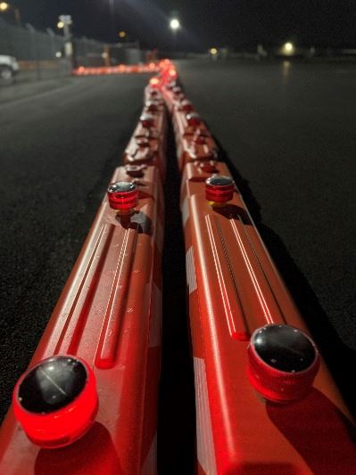 A closeup of orange construction lighted barricades against a night sky at Paine Field